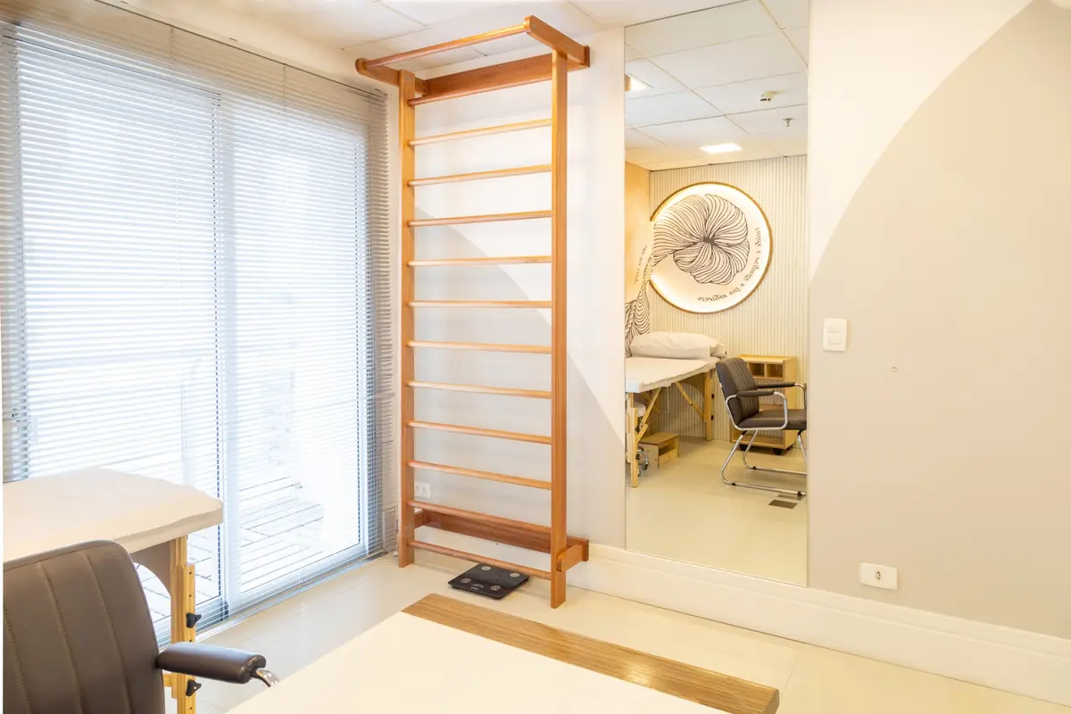 Sala de atendimento multidisciplinar, com espaldar para fisioterapia